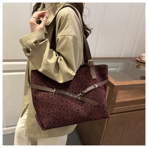 Détail du sac cabas léopard bordeaux avec lanières en cuir marron et boucles dorées