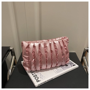 Macro shot of vertical pleated texture on pink satin cloud bag with soft sheen