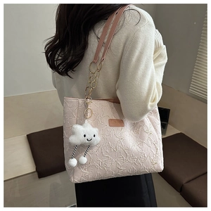 Détail du sac cabas rose matelassé avec chaîne dorée et breloque nuage en peluche