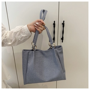 Detail of light blue striped tote bag with sturdy metal rings and woven canvas texture