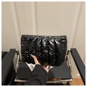 Detail of black glossy cloud pouch showing pleated texture and soft padded material