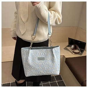 Détail du sac cabas matelassé bleu clair avec broderie étoile et bandoulière chaîne dorée
