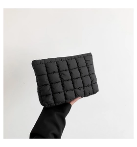 Nahaufnahme der schwarzen gesteppten Puffer-Clutch mit quadratischer Polsterung
