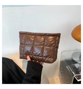 Gros plan sur la pochette matelassée marron montrant sa texture brillante et rembourrée