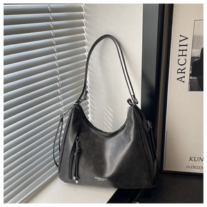 Detail der schwarzen Vintage-Hobo-Tasche mit Reißverschlüssen, Fransen und Lederstruktur