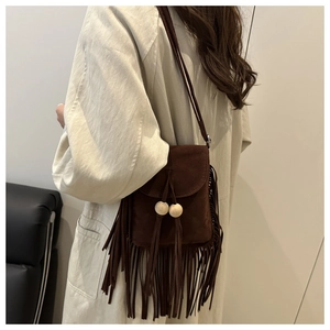 Détail du sac bandoulière bohème en daim marron foncé avec de longues franges et perles