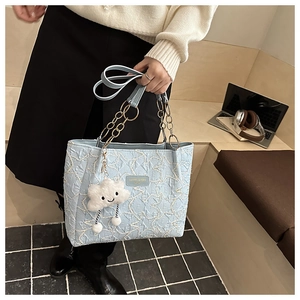 Détail du sac cabas matelassé bleu clair avec coutures étoiles et breloque nuage doux