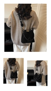 Detail of black matte suede bucket bag with stylish wide woven strap and gold hardware