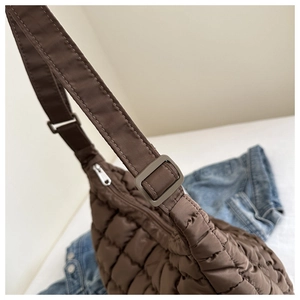 Détail de la bandoulière réglable et texture matelassée du sac bouffant marron