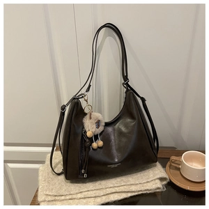 Detail einer dunkelbraunen Hobo-Tasche auf einem Schal mit niedlichem Alpaka-Anhänger