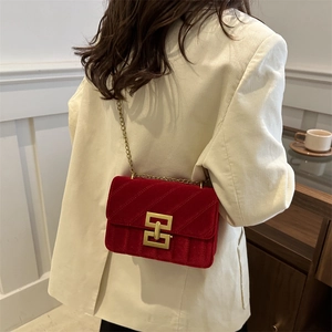 Elegant red velvet quilted chain bag with gold metal hardware shown in a French style setting