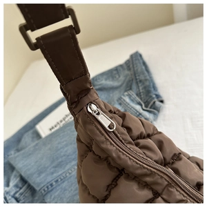 Détail du sac matelassé marron foncé avec fermeture éclair métallique et bandoulière