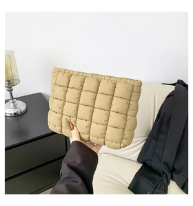 Detail einer hellbraunen gesteppten Cloud-Clutch mit flauschiger Textur bei Innenlicht