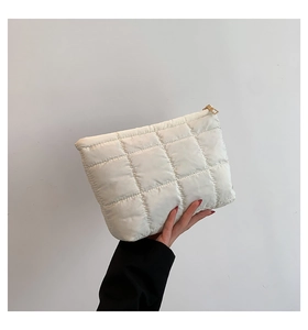 Gros plan du sac à main matelassé blanc crème avec coutures carrées et fermeture éclair dorée