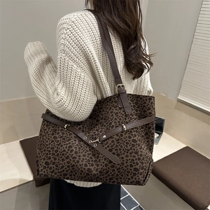 Sac cabas léopard rétro avec poignées en cuir marron porté par un mannequin en pull beige