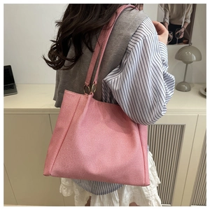 Pink woven tote bag featuring large capacity and stylish golden ring strap detail