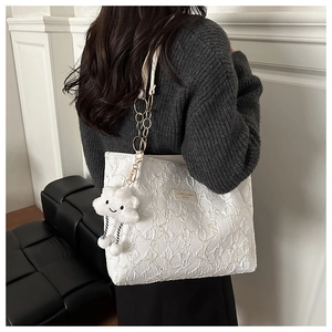 Détail du cabas matelassé blanc avec bandoulière chaîne et charm nuage moelleux
