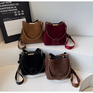 Multiple textured suede bucket bags with metal trim and wide fabric shoulder straps