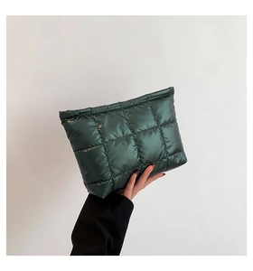 Détail d'une pochette en nylon matelassé vert foncé avec un fini brillant métallisé