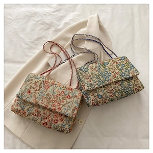 Details der Vintage-Blumenstickerei und Metallkettenriemen an quadratischen Taschen