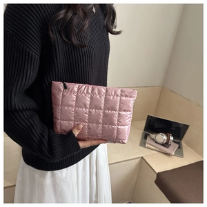 Vue détaillée de la texture matelassée rose doux et de la fermeture éclair du sac