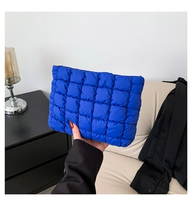 Detail der blau gesteppten Puffer-Clutch mit quadratischer Polsterung und Textur
