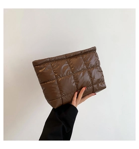 Détail d'une pochette matelassée marron brillante avec surpiqûres carrées élégantes