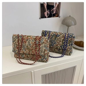 Detail der floralen Jacquard-Struktur und Metallkette an Vintage-Schultertaschen