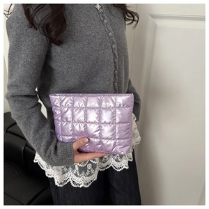 Macro shot of purple quilted makeup bag featuring a metallic finish and square stitching