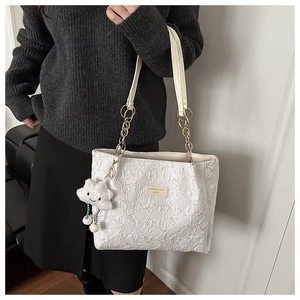 Détail du sac cabas blanc matelassé avec chaîne dorée et breloque nuage en peluche