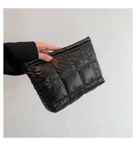 Détail de la pochette matelassée noire en nylon brillant avec texture rembourrée