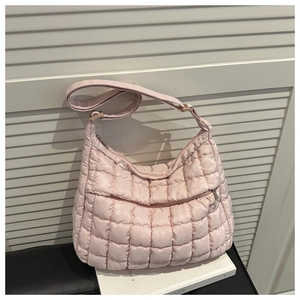 Détail du sac matelassé rose montrant la texture rembourrée et la bandoulière réglable
