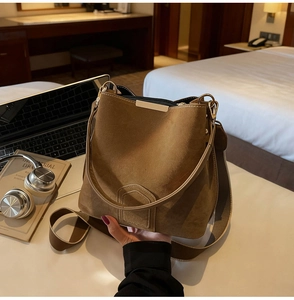 Detailed view of brown suede bucket bag with fine velvet texture and metallic hardware