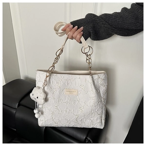 Détails de la texture étoilée du sac cabas avec breloque nuage et chaîne métallique