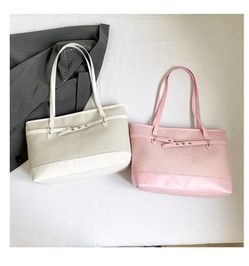 Detail view of stylish woven contrast tote bags in beige and pink for daily commute
