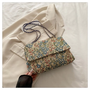 Detailaufnahme des floralen Stickstoffs und des Metallkettenriemens einer Vintage-Tasche