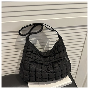 Vue détaillée du sac matelassé noir à bulles avec bandoulière réglable sur cuir