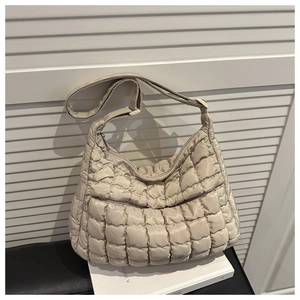 Vue détaillée du sac cabas matelassé beige avec texture gonflée et large bandoulière