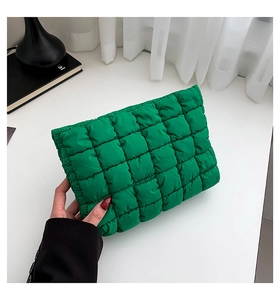 Detail der grünen gesteppten Bubble-Clutch mit stilvoller Plissee-Textur und seidigem Nylon-Finish