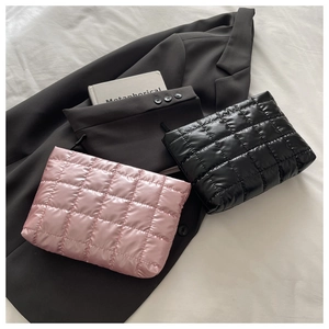 Gros plan détaillé de pochettes en nylon matelassé rose et noir sur un blazer texturé
