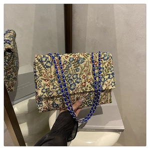 Nahaufnahme der floralen Stickerei und der blauen Kette an der Vintage-Umhängetasche