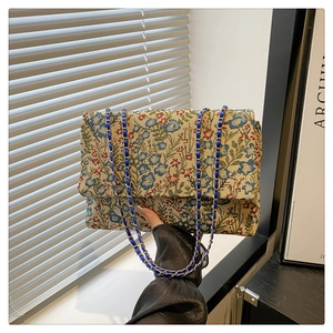 Detailansicht der Ethno-Blumenstickerei und Leder-Kettenschultergurt an kleiner Klapptasche