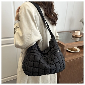 Détail du sac nuage noir matelassé avec texture bouffante et large bandoulière