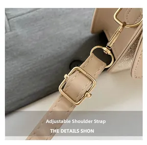Detail of adjustable light beige faux leather strap with polished gold-tone metal hardware