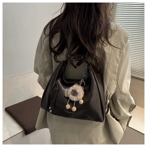 Detailansicht braune PU-Leder Hobo-Tasche mit flauschigem Schaf-Anhänger und Textmuster