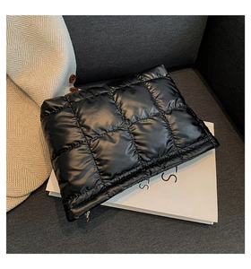 Détail du sac à main matelassé noir avec coutures à grands carreaux et texture brillante