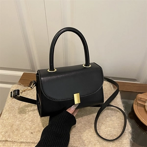 Chic black mini crossbody bag with gold rectangular lock and structured top handle