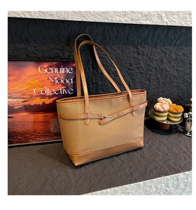 Close-up of vintage brown tote bag featuring mixed textures and leather strap detail