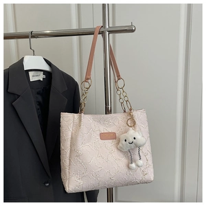 Détail du sac cabas rose avec broderie d'étoiles et charm nuage peluche sur chaîne