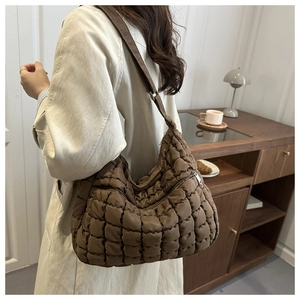 Détails de la texture matelassée du sac marron avec fermeture éclair métallique